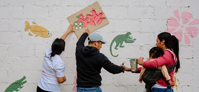 Adultos trabajan con llantas pintadas en el patio del jardín
