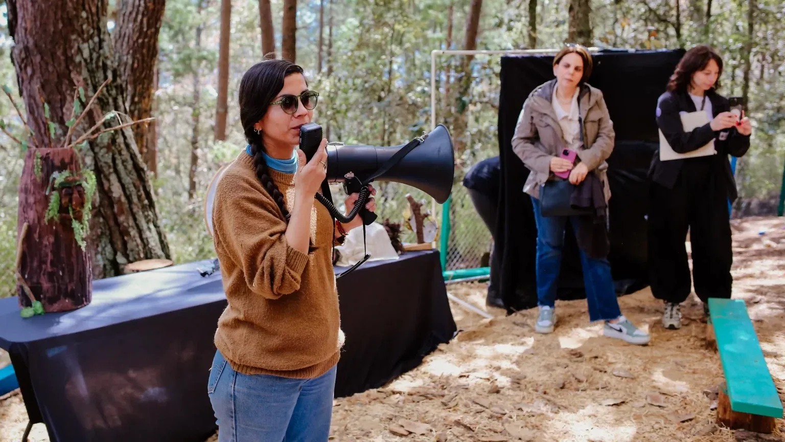 Una mujer habla con megáfono durante la ceremonia de activación del espacio