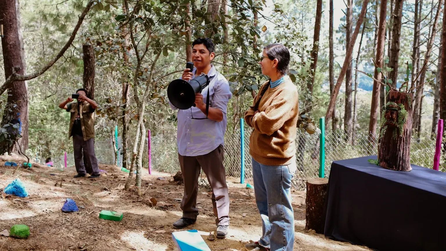 Integrantes de la comunidad hablan con megáfono en el espacio del bosque