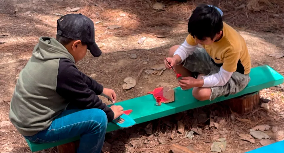 Dos niñas juegan y construyen sobre la tierra en una actividad comunitaria al aire libre